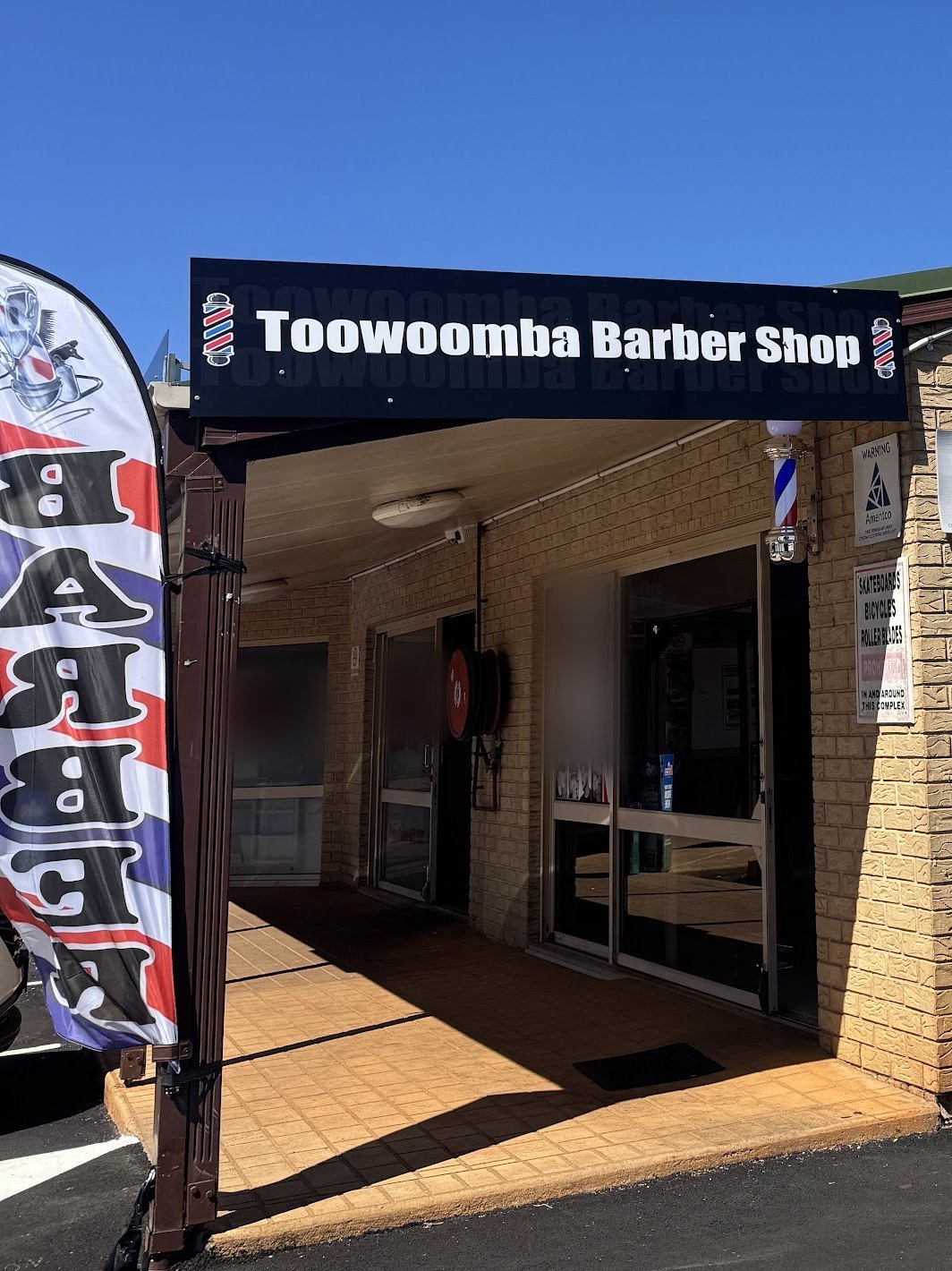 The covered entrance to the shop under the black Toowoomba Barber Shop sign