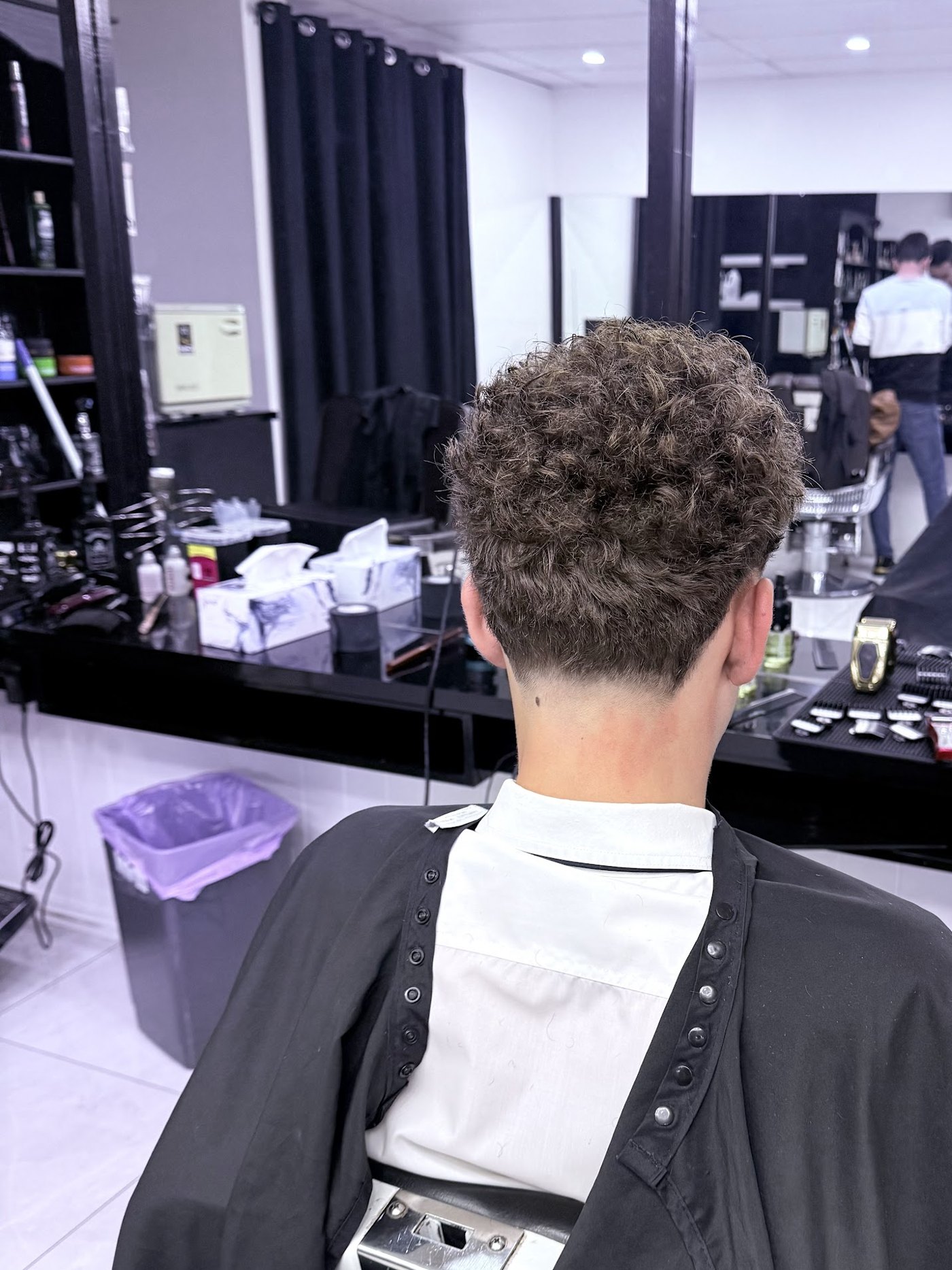 Low taper fade with a full curly top