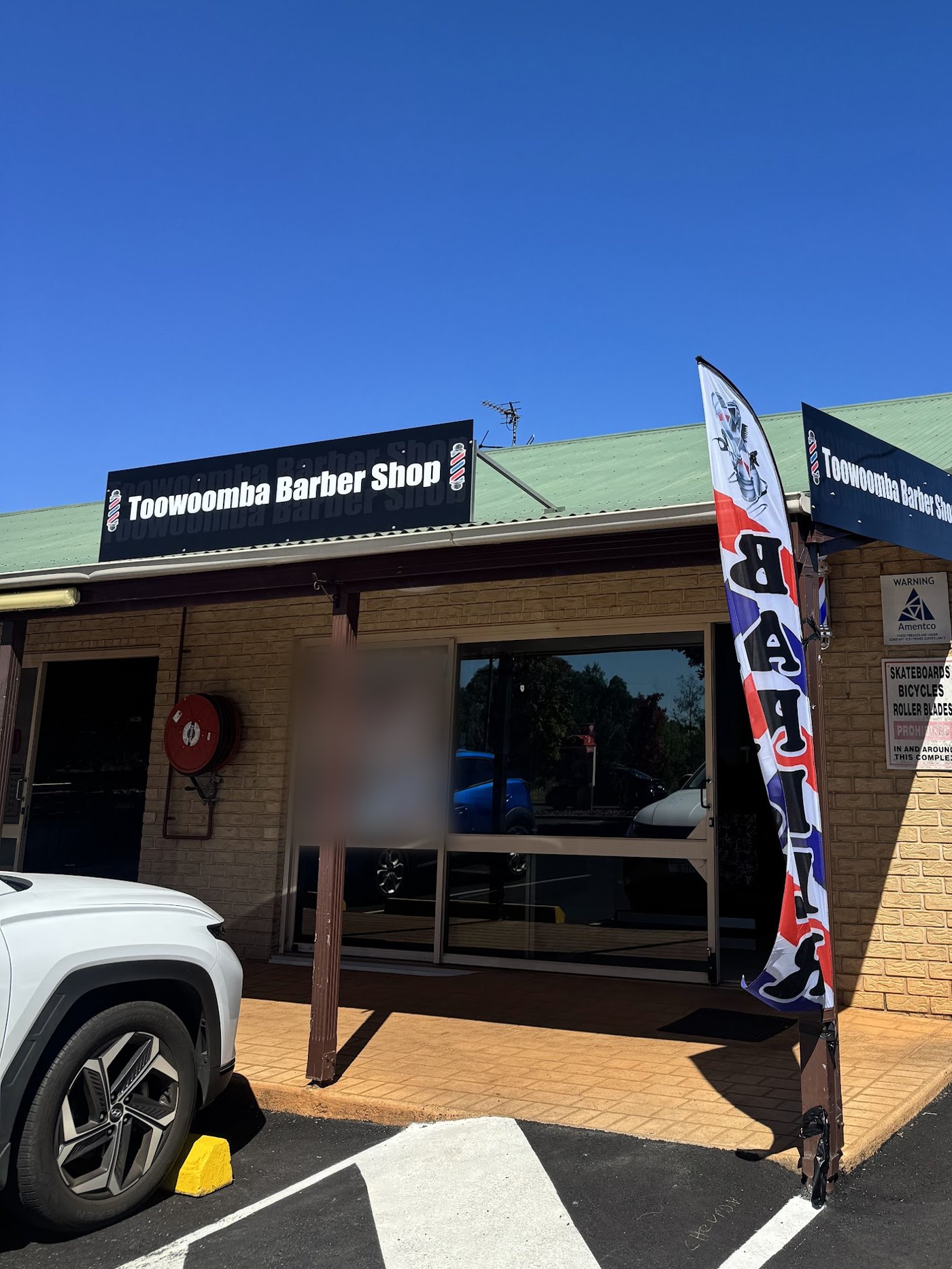 The Toowoomba Barber Shop shopfront and barber flag on Spring Street